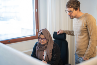 Kaksi palveluneuvojaa katsoo tietokoneen ruutua Hekan toimistossa.