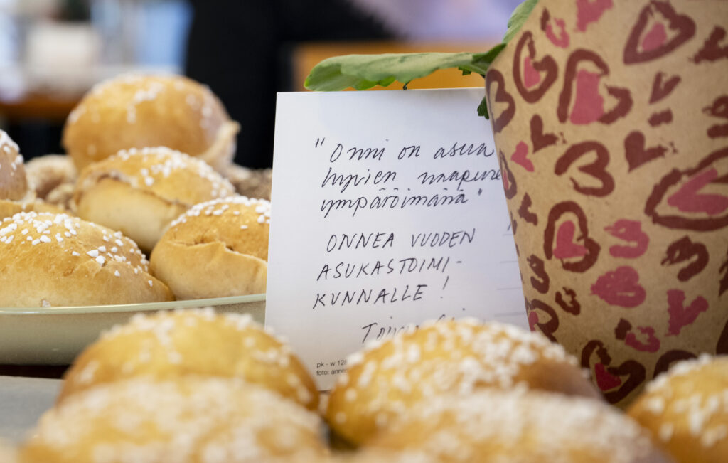 Pullia ja lappu, jossa onnitellaan vuoden asukastoimikuntaa.