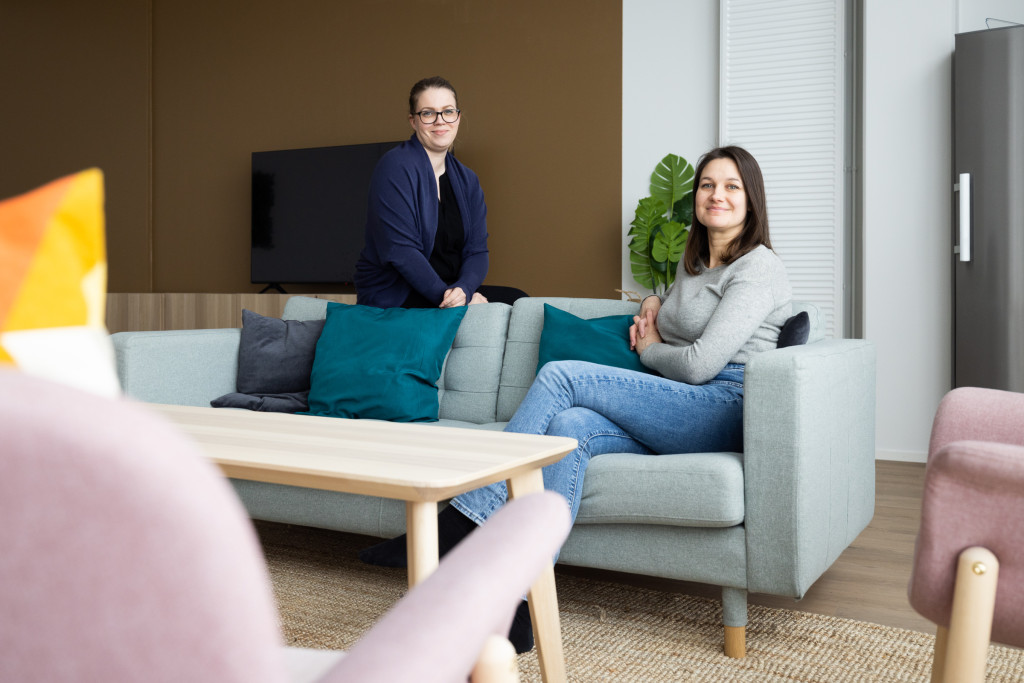 Hanna Härkönen ja Annika Voutilainen kerhohuoneella sohvan ympärillä.