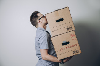 Mies kantaa muuttolaatikoita