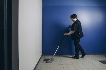 Siivooja pesemässä lattiaa.