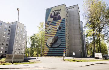 Kaksi kerrostaloa. Toisen kerrostalon yhdellä seinällä on suuri värikäs seinämaalaus