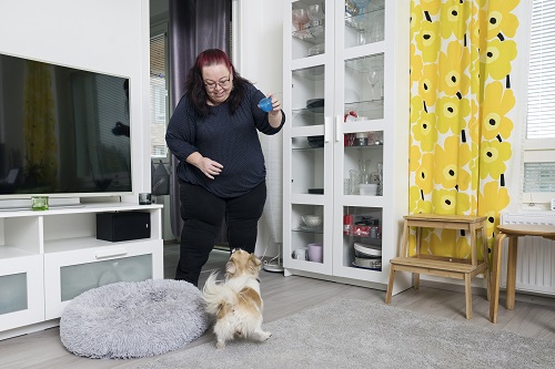 Sari Lindfors leker med sin hund Maisa i vardagsrummet.