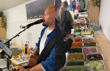 Henkilö esiintyy mikrofonin kanssa yhteistilassa ja soittaa kitaraa. Vieressä on buffetpöytä, jolle on katettu ruokaa ja juomia juhlaväelle.