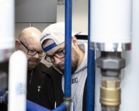 Hekan huollon työntekijä Kari Lundberg ja RAU-valvoja Mika Ringborg näkyvät putkistojen takaa.