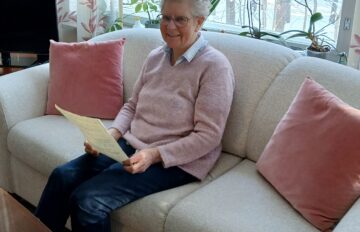 Solveig istuu sohvalla ja pitää kädessään vuokrasopimusta.