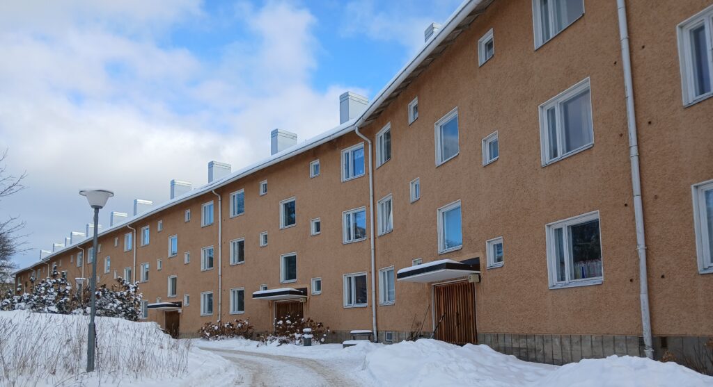 Rapattu keltainen kolmikerroksinen kerrostalo.