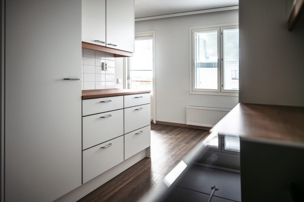 Bilden visar en bostad fotograferad från köket, kökets bänkar och fönster.
