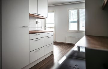 Bilden visar en bostad fotograferad från köket, kökets bänkar och fönster.