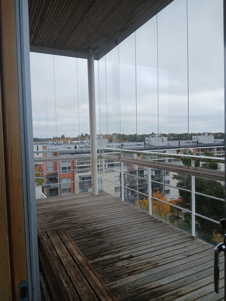 Lasitettu parveke, josta maisema lähitalojen kattojen yli.
